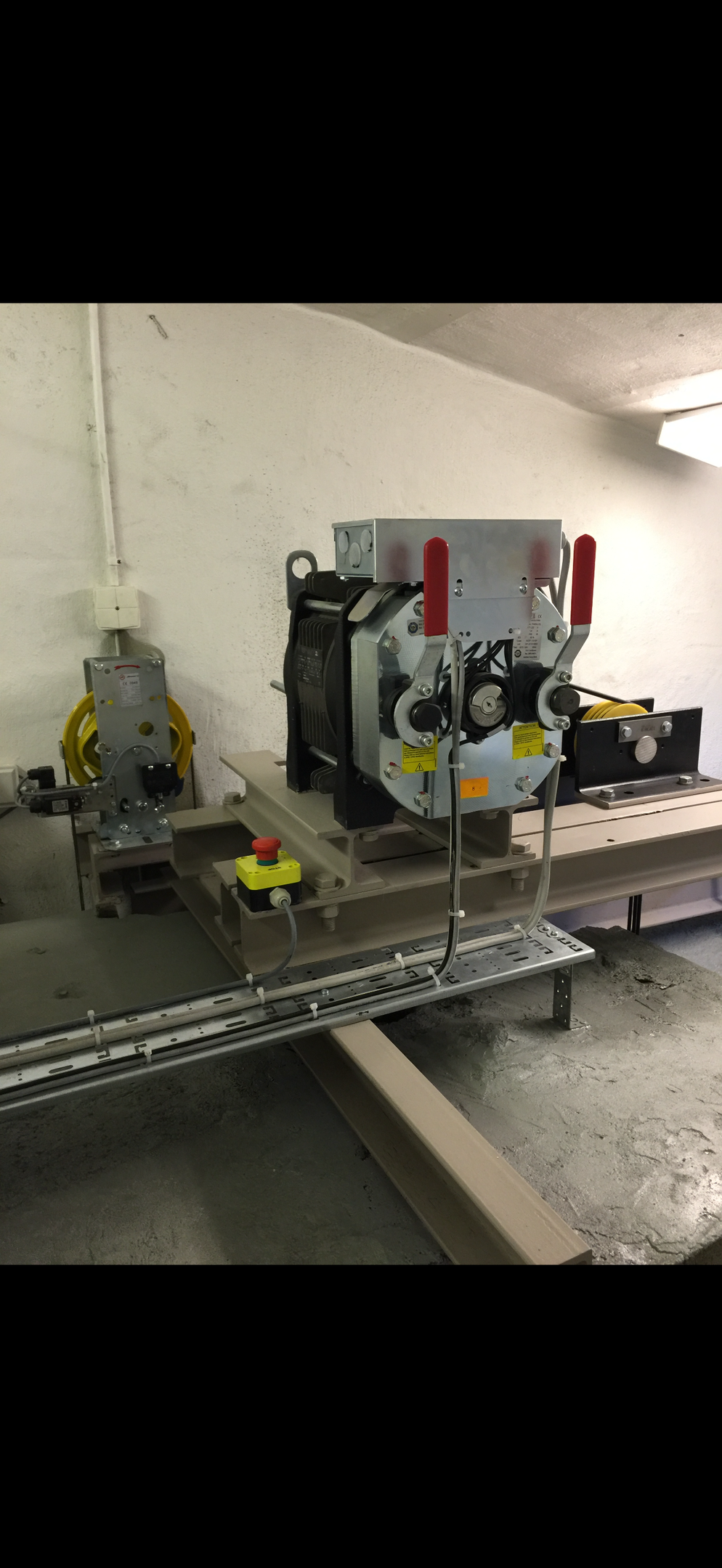 Specialist fixing or adjusting lift mechanism in elevator schaft. Regular repair, service and maintenance of elevator.